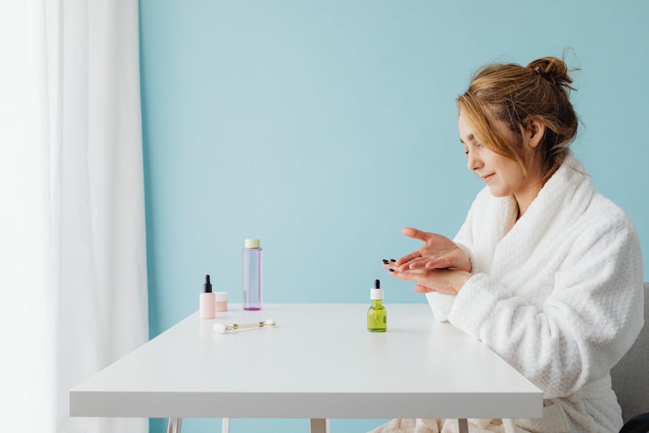Woman in bathrobe applying skincare products at a table in a bright studio setting
