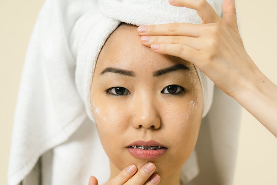 A woman applies facial cream during her daily skincare routine