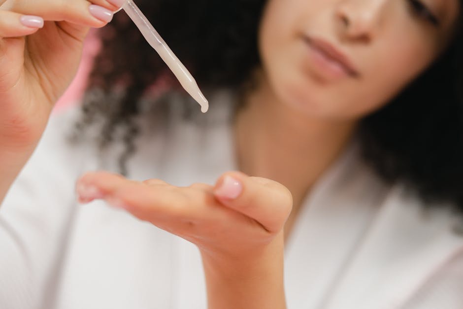 Close-up of a woman applying skincare serum with a pipette